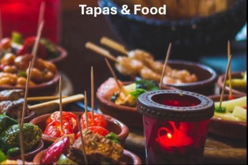 Tapas-Auswahl mit Spiesschen und Kerzenlicht